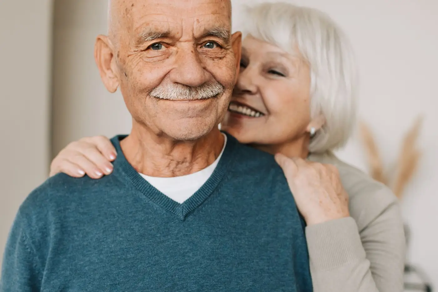 Casal de idosos abraçado e sorrindo